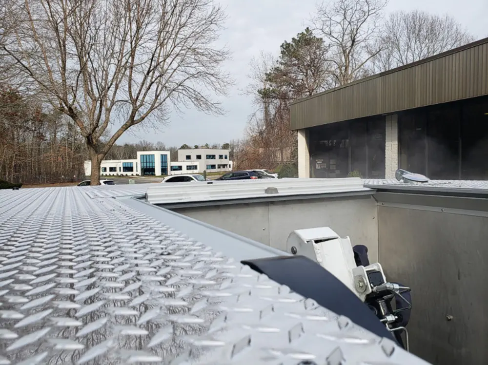 Exterior view of small fire truck showing cab, body compartments, and wheel/tire area.