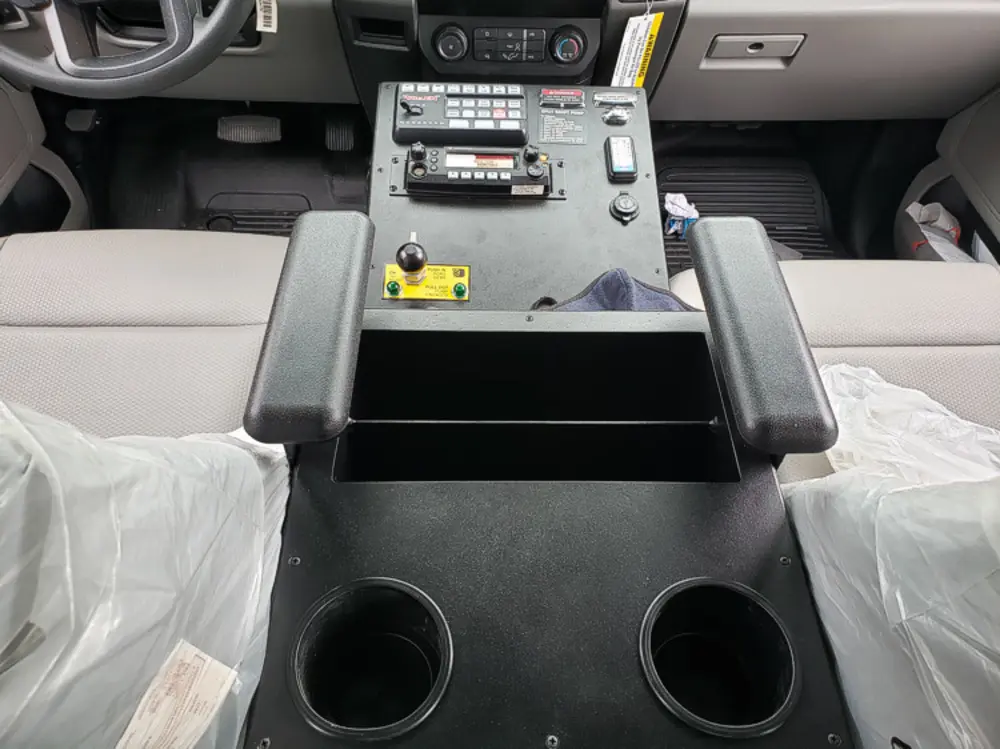 Exterior view of small fire truck showing cab, body compartments, and wheel/tire area.