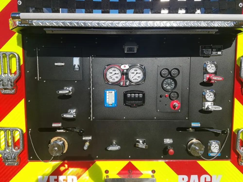 Exterior view of small fire truck showing cab, body compartments, and wheel/tire area.