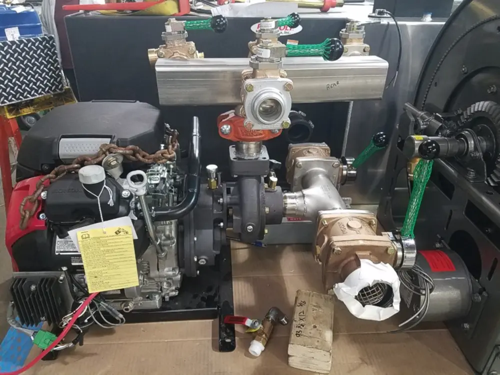 Exterior view of small fire truck showing cab, body compartments, and wheel/tire area.