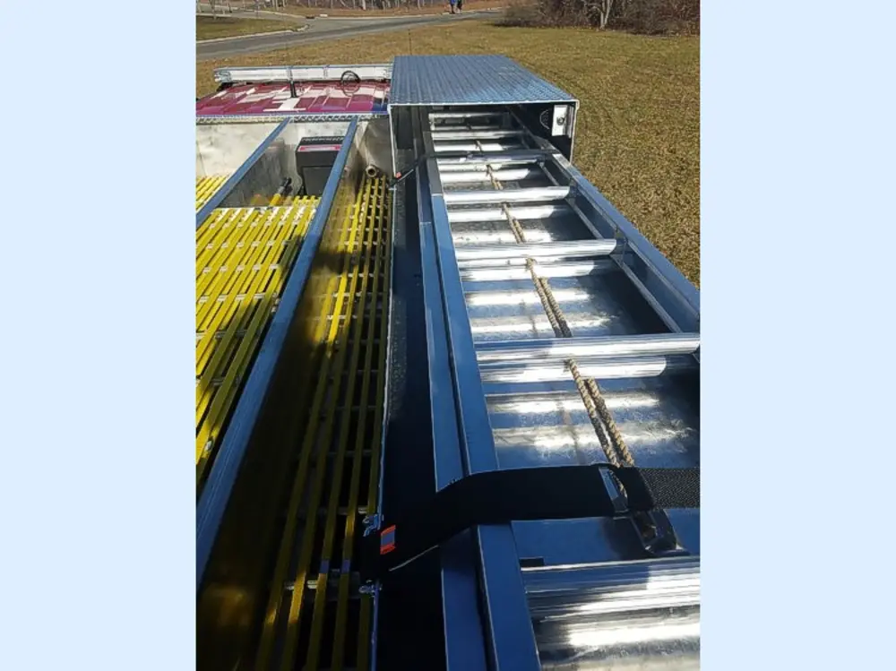 Exterior view of small fire truck showing cab, body compartments, and wheel/tire area.