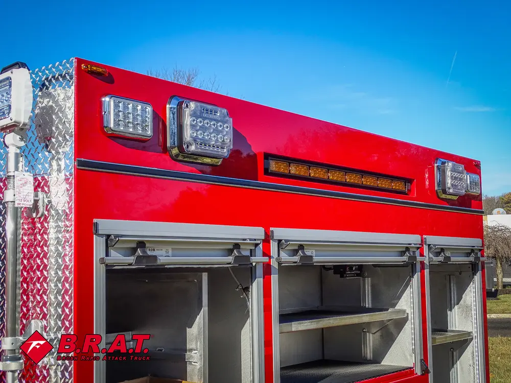 Upper side body section with compartment doors open beneath warning lights.