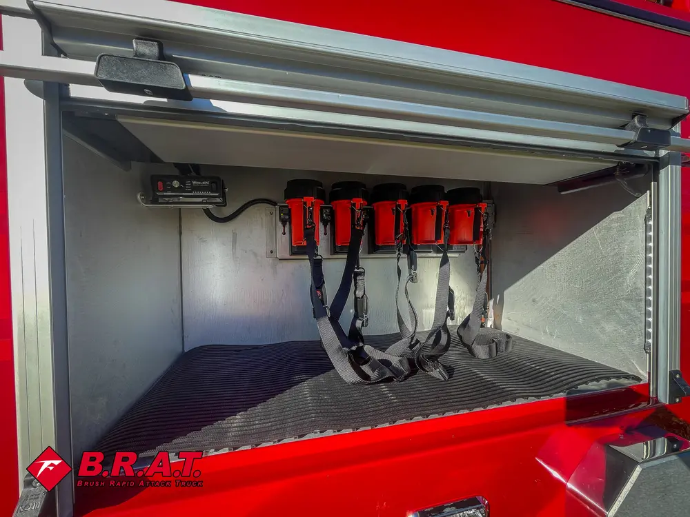 Open side compartment with mounted red equipment packs and floor tray.