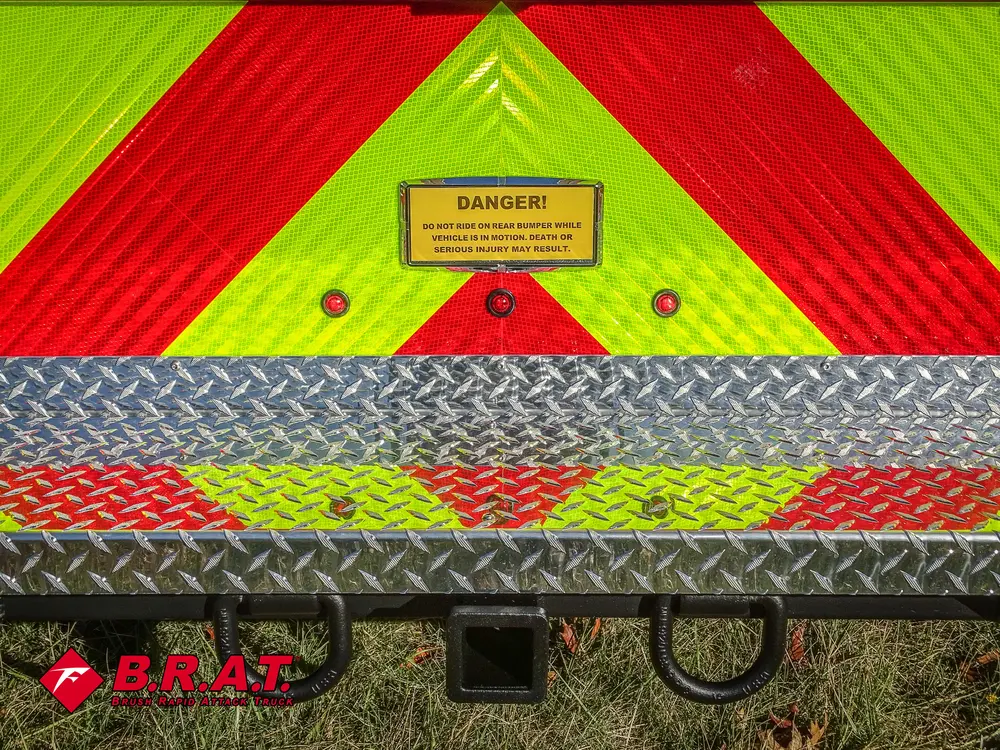 Rear lower panel close-up with caution label and tow hooks.