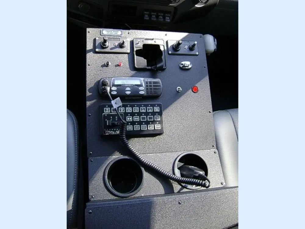 Exterior view of small fire truck showing cab, body compartments, and wheel/tire area.