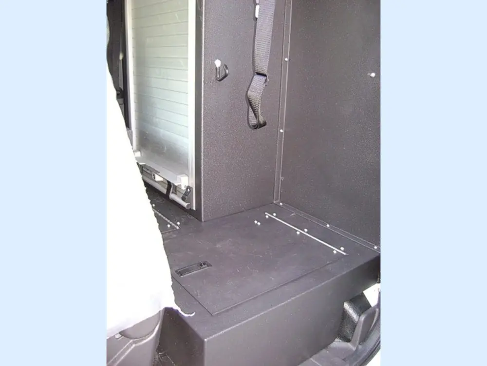 Exterior view of small fire truck showing cab, body compartments, and wheel/tire area.