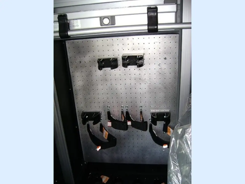 Exterior view of small fire truck showing cab, body compartments, and wheel/tire area.