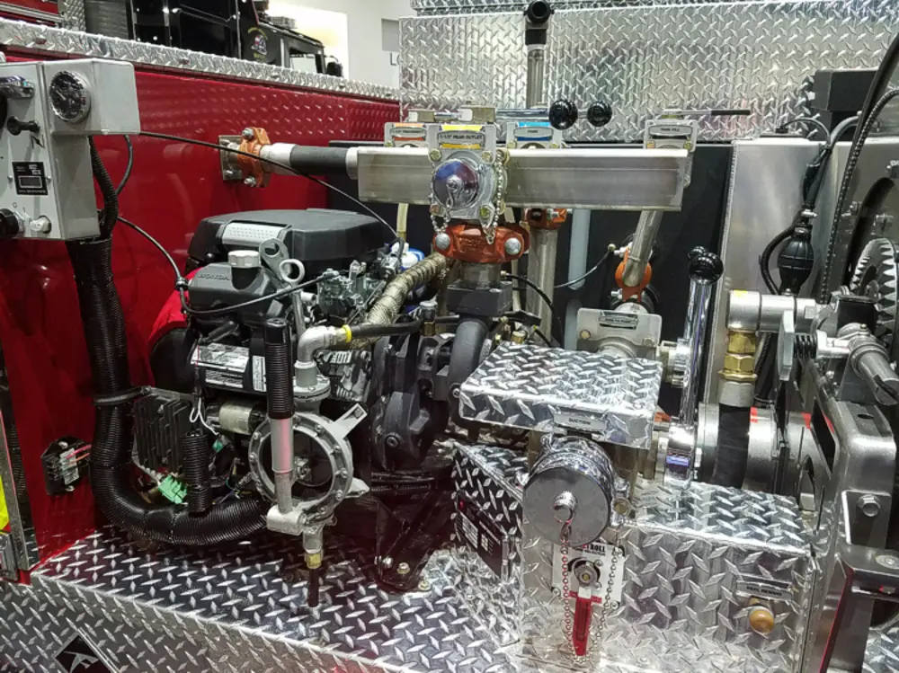 Exterior view of small fire truck showing cab, body compartments, and wheel/tire area.