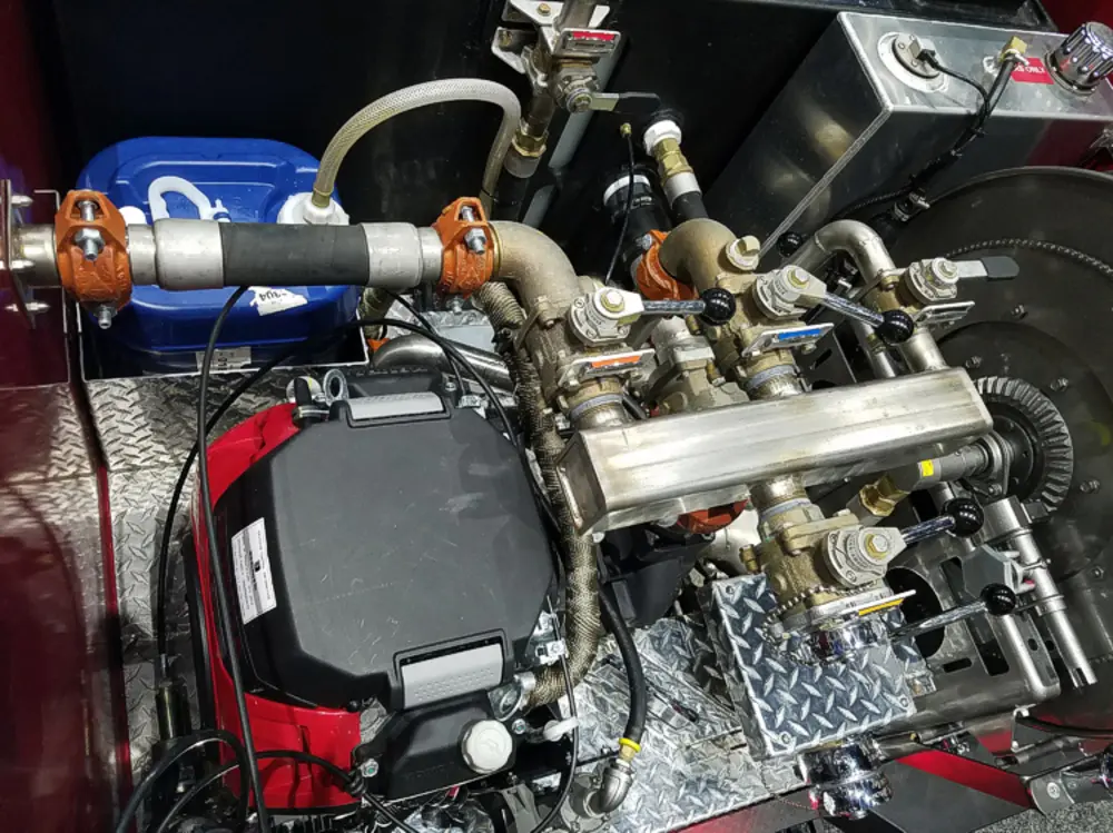 Exterior view of small fire truck showing cab, body compartments, and wheel/tire area.