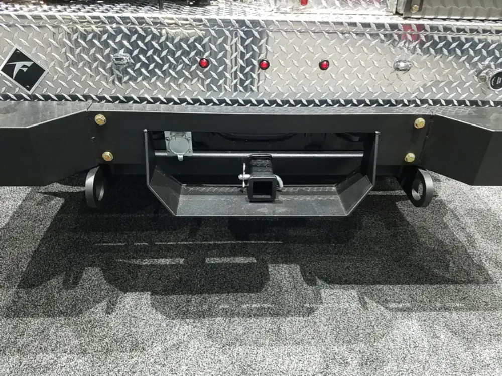 Exterior view of small fire truck showing cab, body compartments, and wheel/tire area.