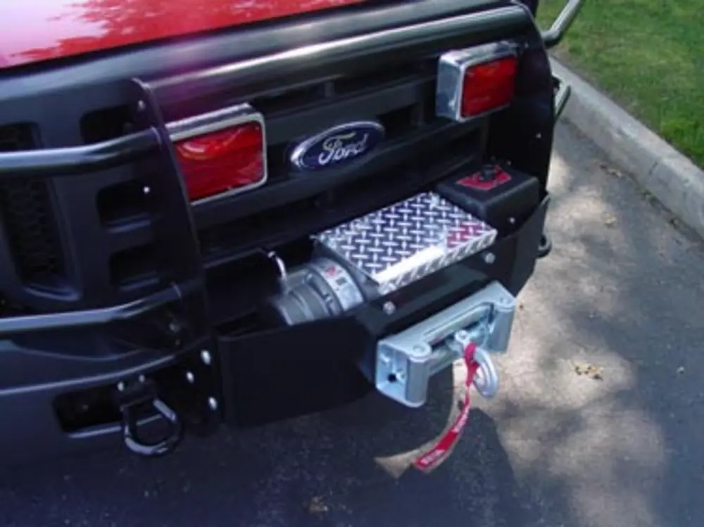 Exterior view of small fire truck showing cab, body compartments, and wheel/tire area.