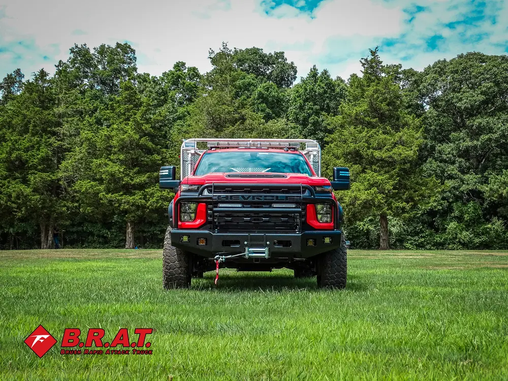 Exterior view of small fire truck showing cab, body compartments, and wheel/tire area.