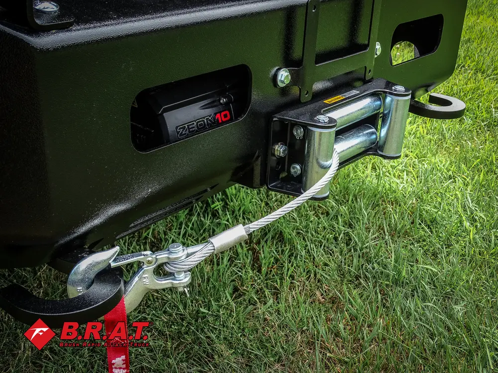 Exterior view of small fire truck showing cab, body compartments, and wheel/tire area.