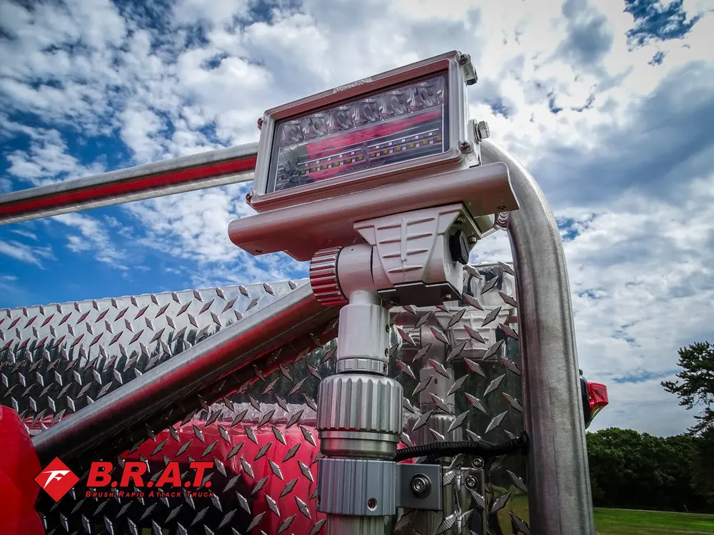 Exterior view of small fire truck showing cab, body compartments, and wheel/tire area.