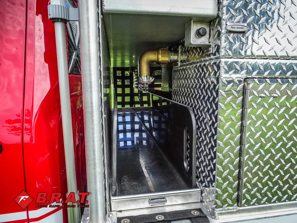 Exterior view of small fire truck showing cab, body compartments, and wheel/tire area.