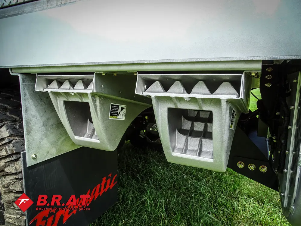 Exterior view of small fire truck showing cab, body compartments, and wheel/tire area.