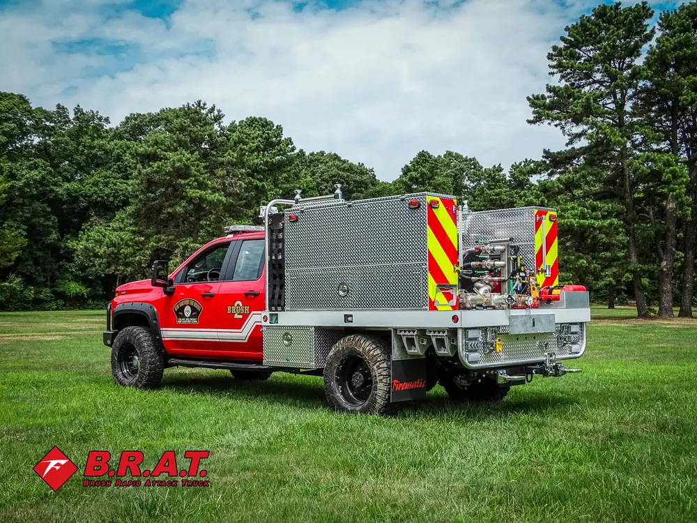 Exterior view of small fire truck showing cab, body compartments, and wheel/tire area.