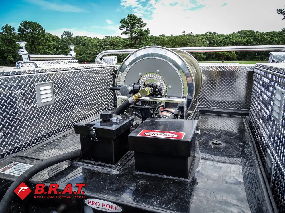 Exterior view of small fire truck showing cab, body compartments, and wheel/tire area.