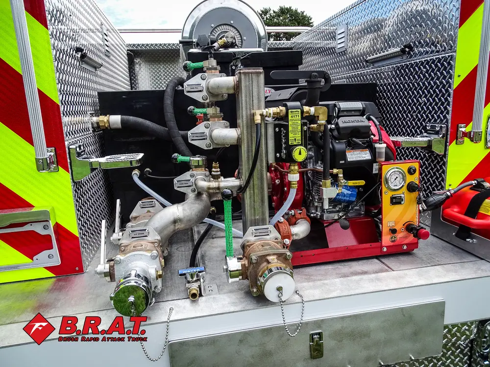 Exterior view of small fire truck showing cab, body compartments, and wheel/tire area.