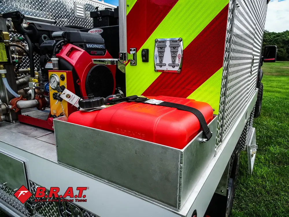 Exterior view of small fire truck showing cab, body compartments, and wheel/tire area.