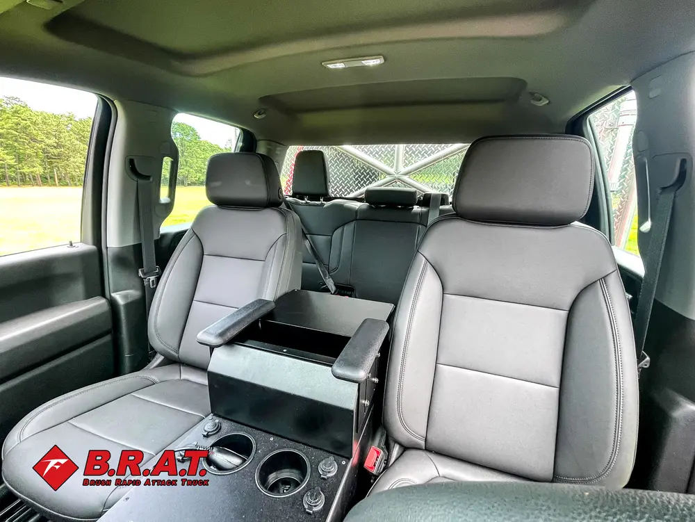 Exterior view of small fire truck showing cab, body compartments, and wheel/tire area.