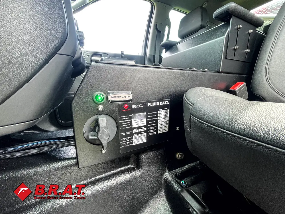 Exterior view of small fire truck showing cab, body compartments, and wheel/tire area.