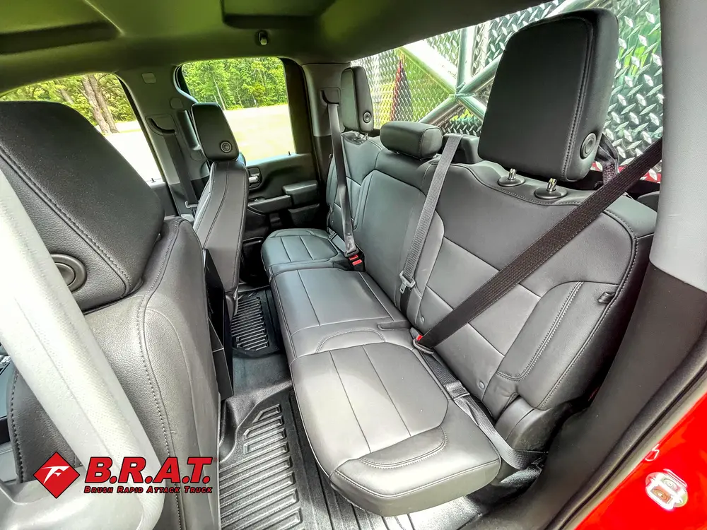 Exterior view of small fire truck showing cab, body compartments, and wheel/tire area.