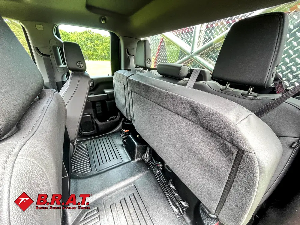 Exterior view of small fire truck showing cab, body compartments, and wheel/tire area.