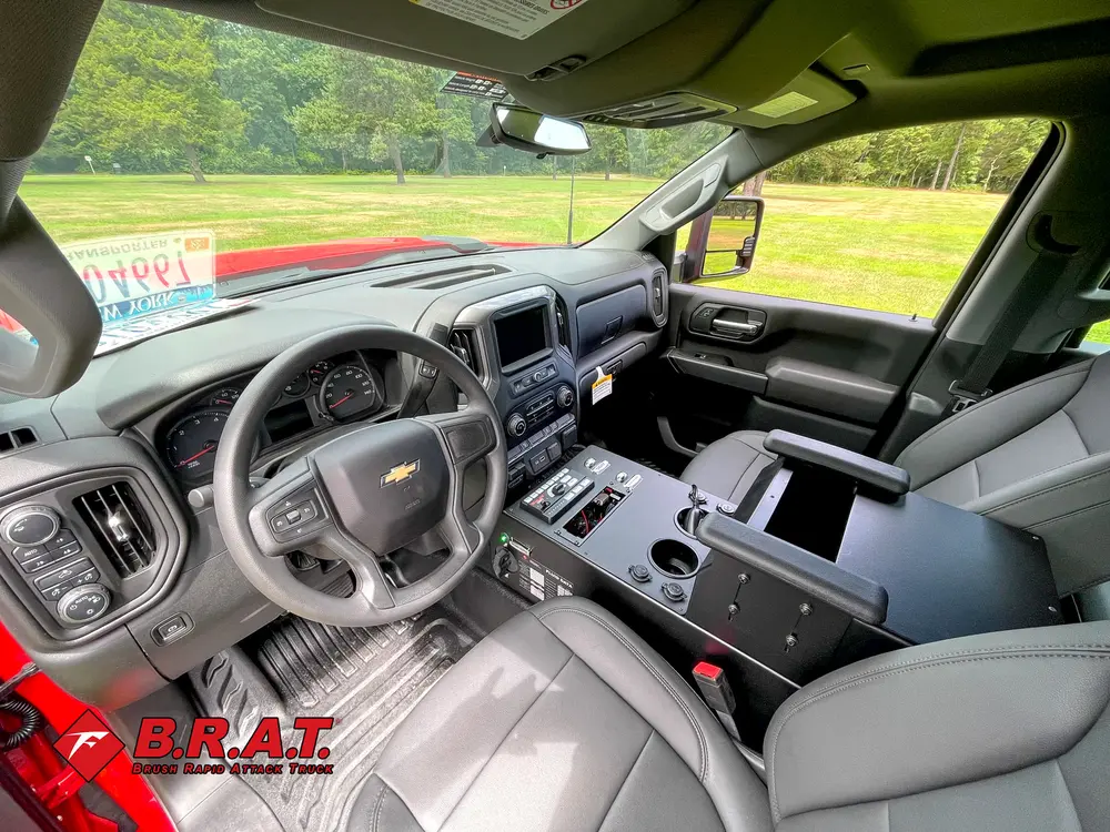 Exterior view of small fire truck showing cab, body compartments, and wheel/tire area.