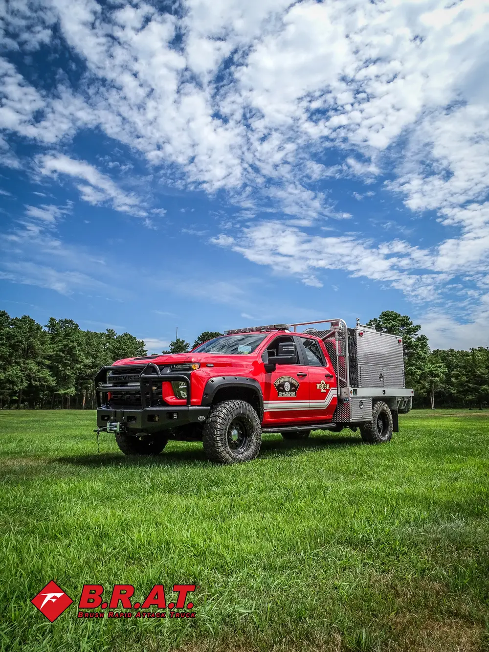 Exterior view of small fire truck showing cab, body compartments, and wheel/tire area.