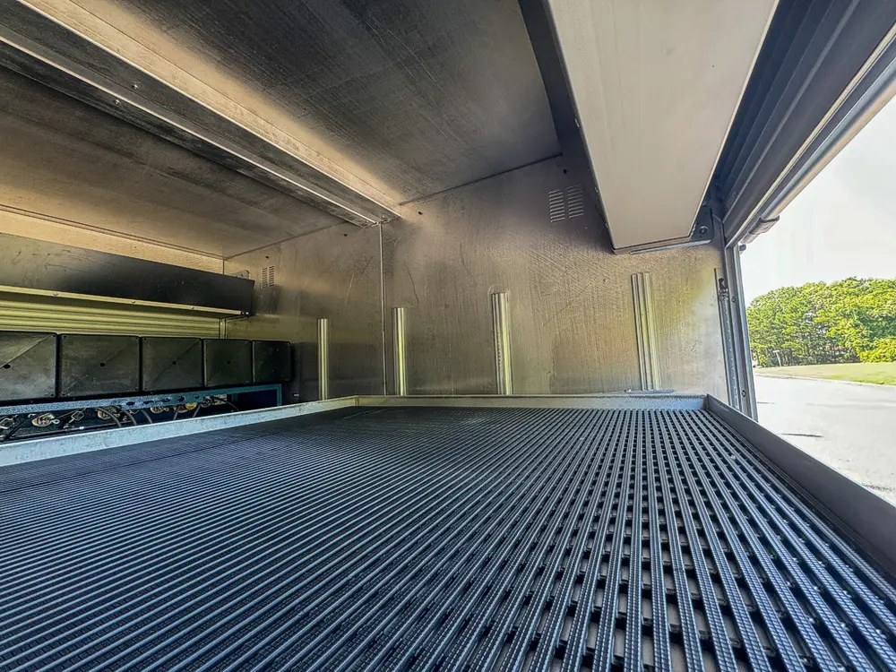 Wide compartment interior showing low ceiling shelf and ribbed floor.