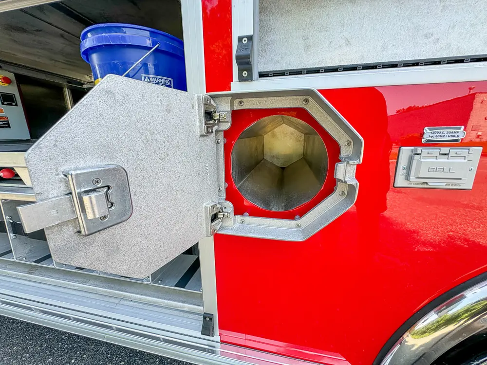 Octagonal side intake-port hatch open showing capped fitting.