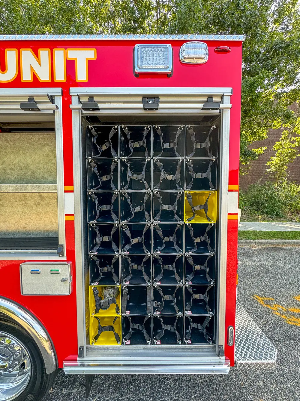 Vertical side rack with multiple SCBA bottle slots and storage pockets.