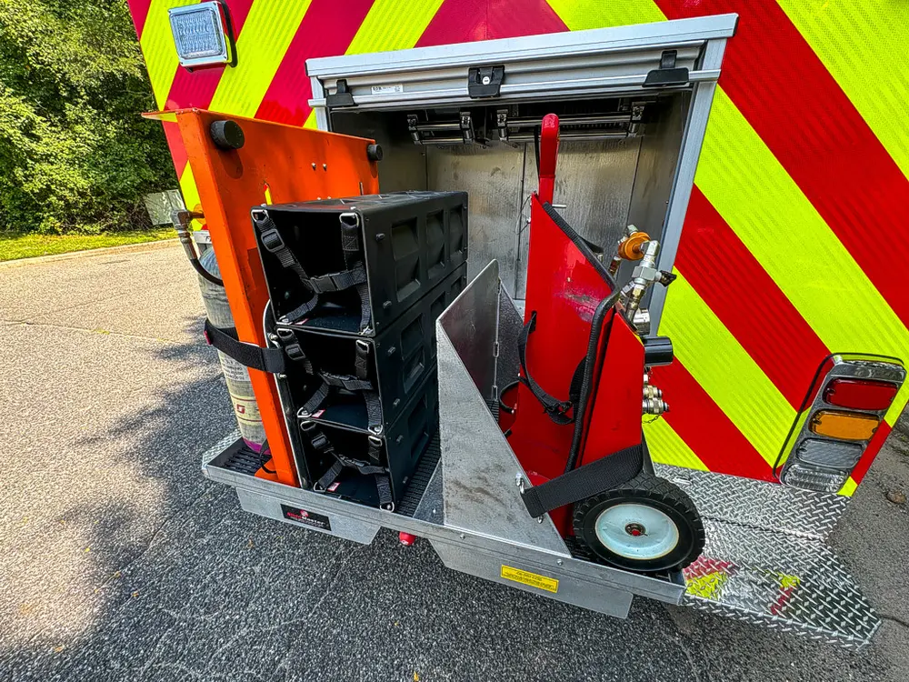 Rear compartment with pull-out tool rack and extinguisher visible.