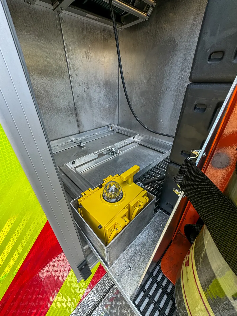 Compartment floor close-up with yellow tie-down ring and drain area.