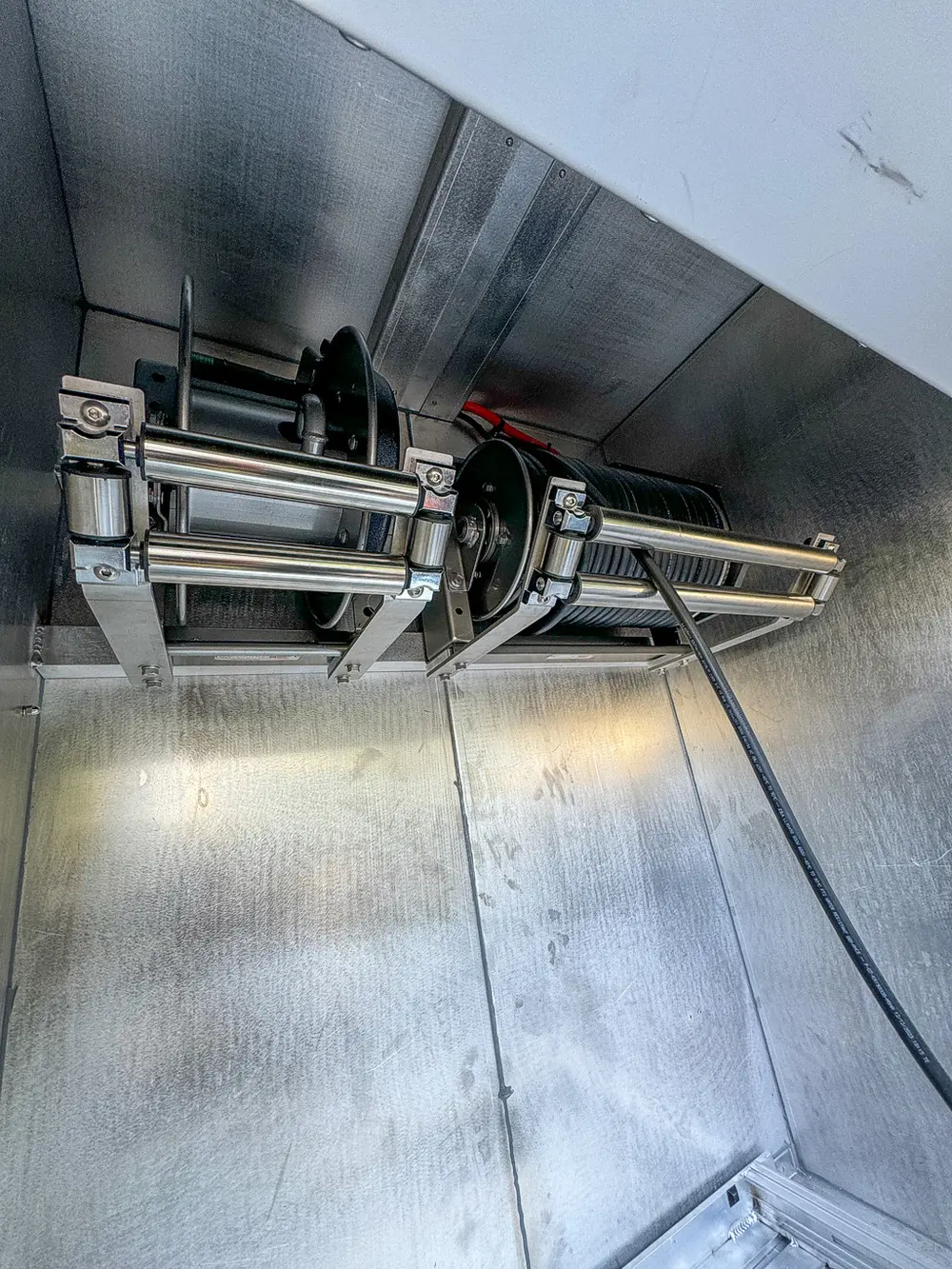 Compartment interior showing mounted hydraulic cylinder and slide mechanism.