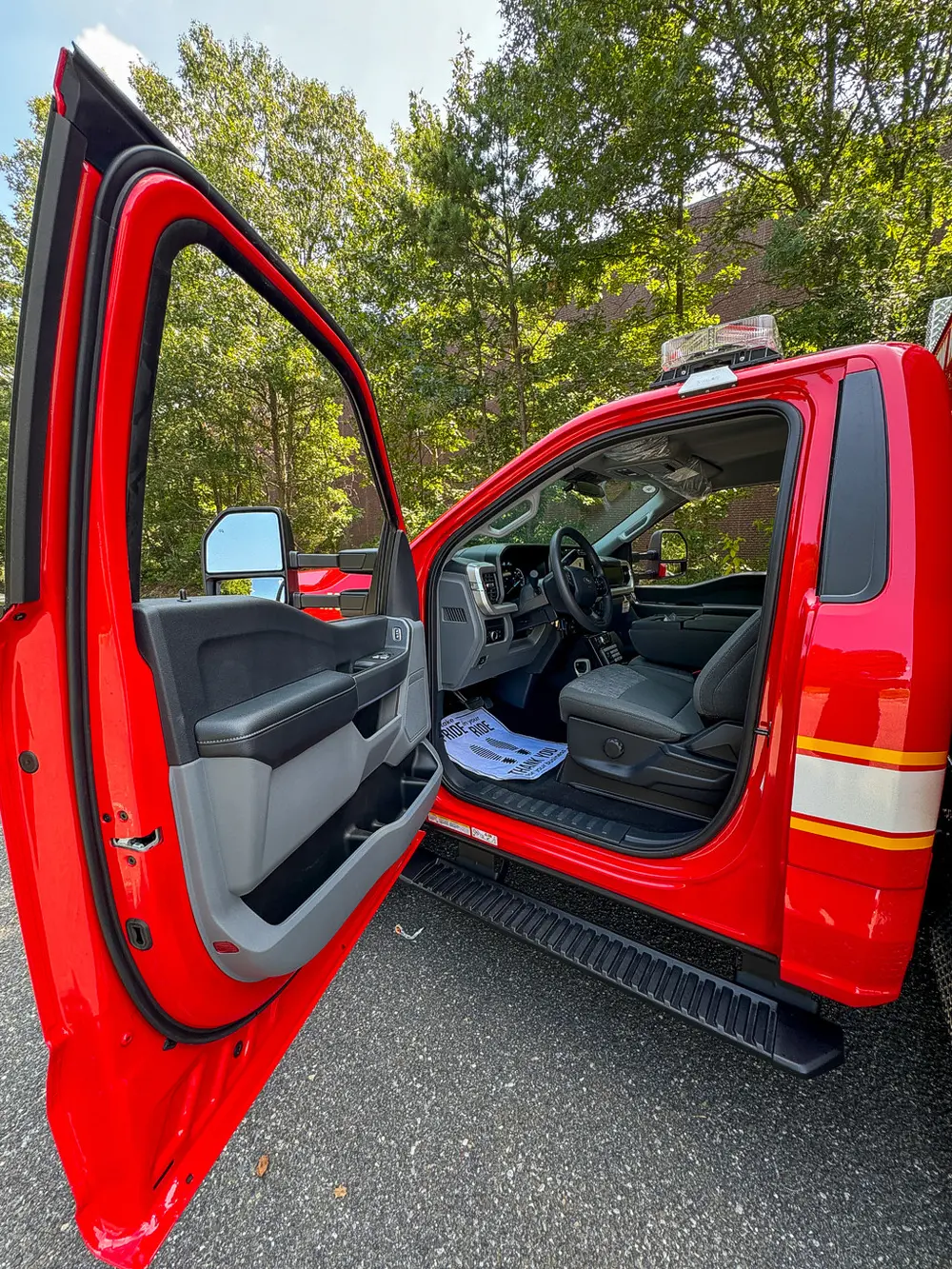 Open driver door view showing front seat and dash entry.