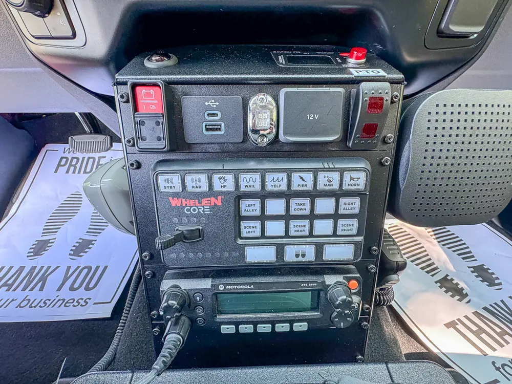 Center console close-up with radio stack and Whelen control keypad.