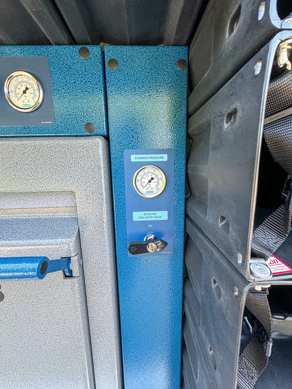 Blue control plate close-up with pressure gauge and valve handle.