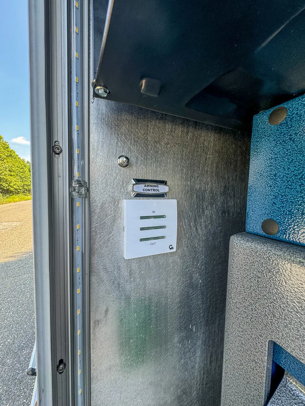 Narrow compartment panel with warning labels and vented slots.