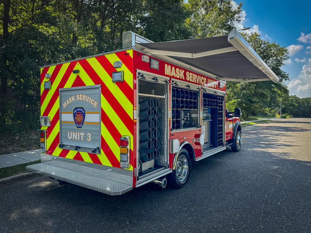 Rear-right three-quarter view with side compartments and rear hatch open.