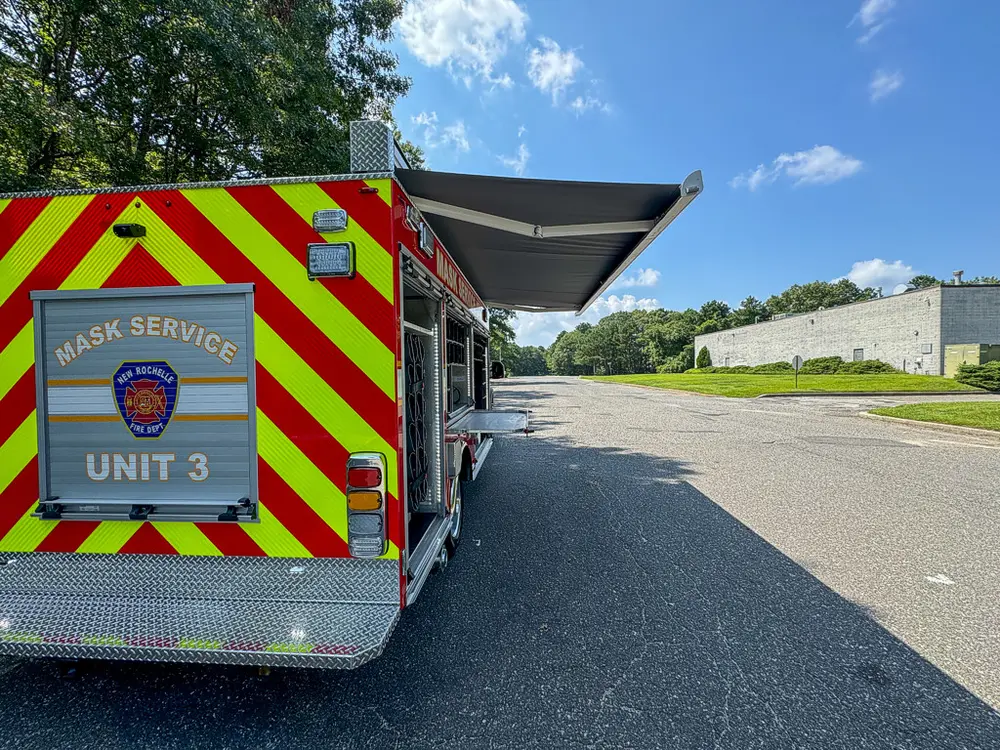 Rear-right corner view showing chevron rear door and open side awning.