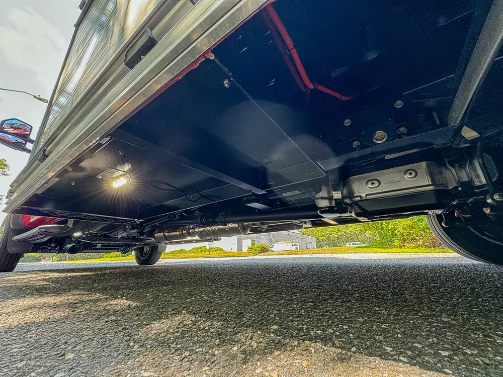 Undercarriage close-up showing frame components beneath side compartments.
