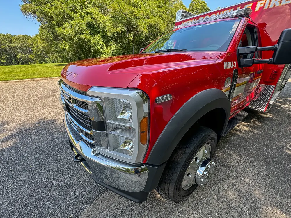 Front-right exterior close-up of cab, grille, and wheel area.