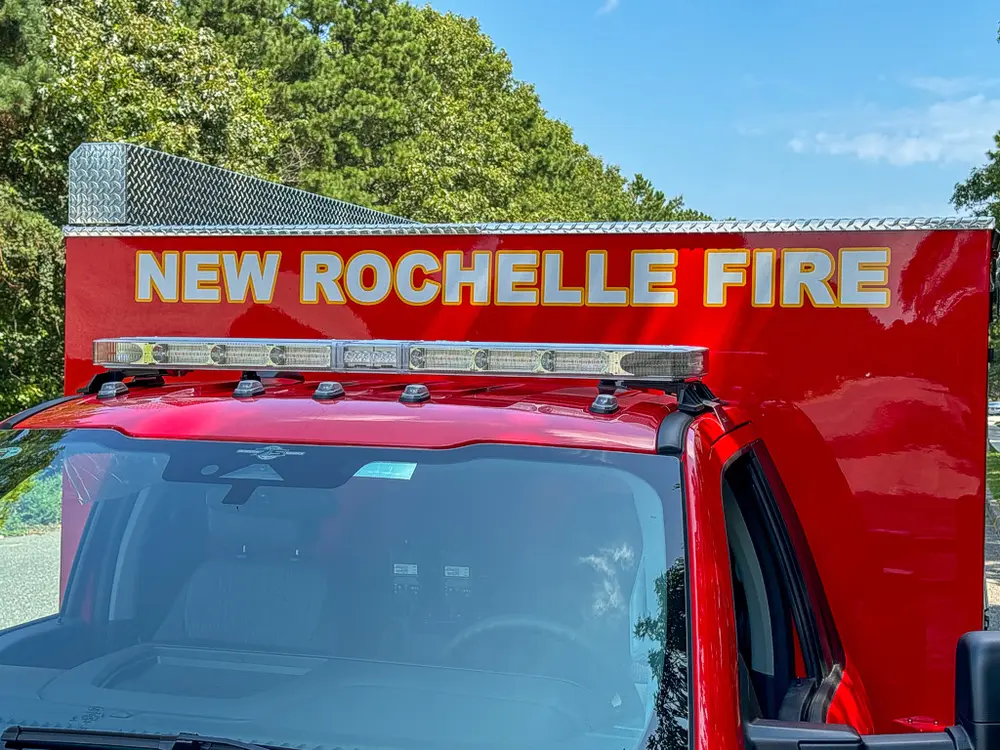 Cab roof and front body sign close-up reading New Rochelle Fire.