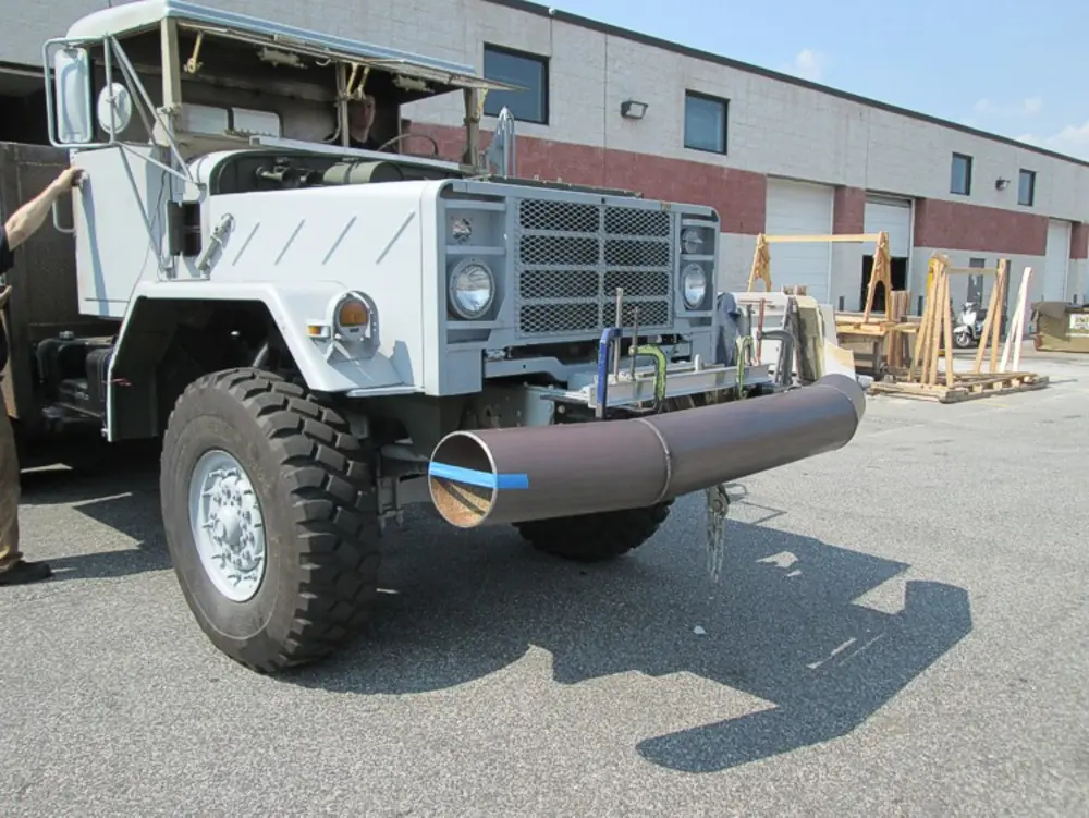 Exterior view of small fire truck showing cab, body compartments, and wheel/tire area.