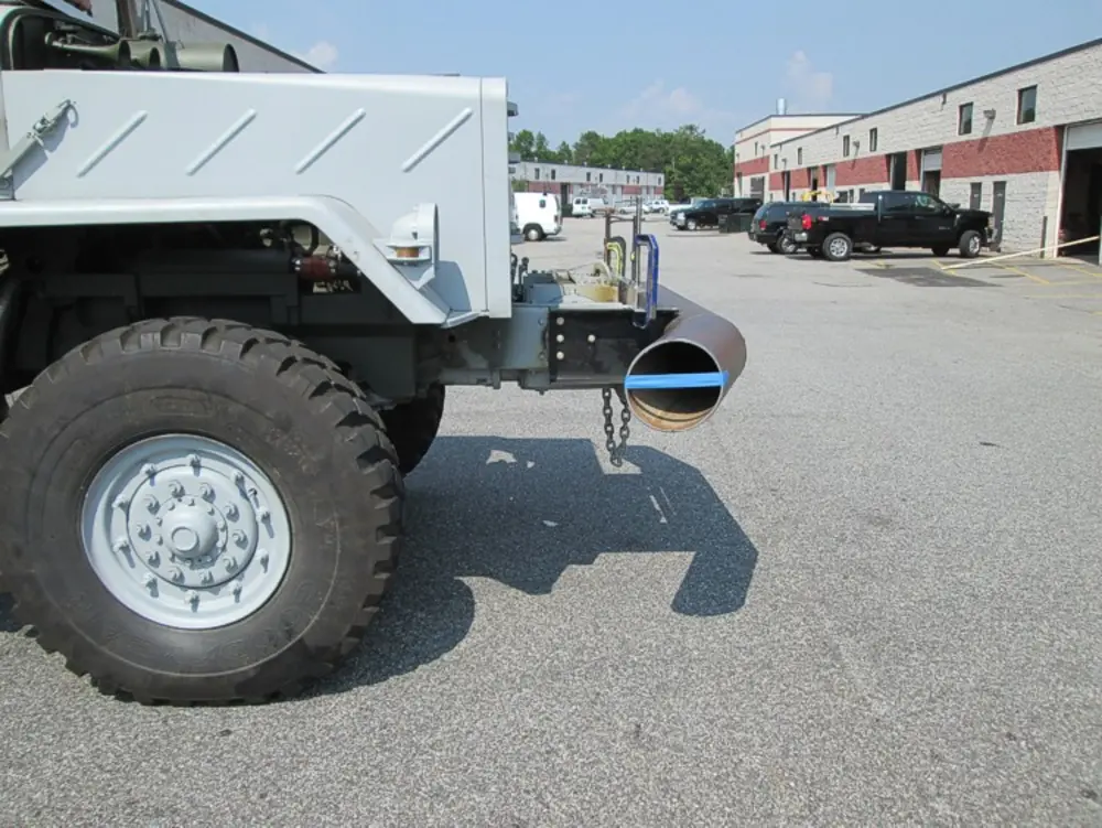 Exterior view of small fire truck showing cab, body compartments, and wheel/tire area.
