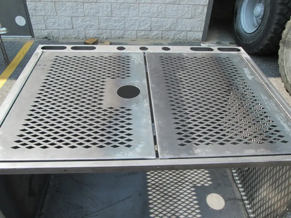 Exterior view of small fire truck showing cab, body compartments, and wheel/tire area.