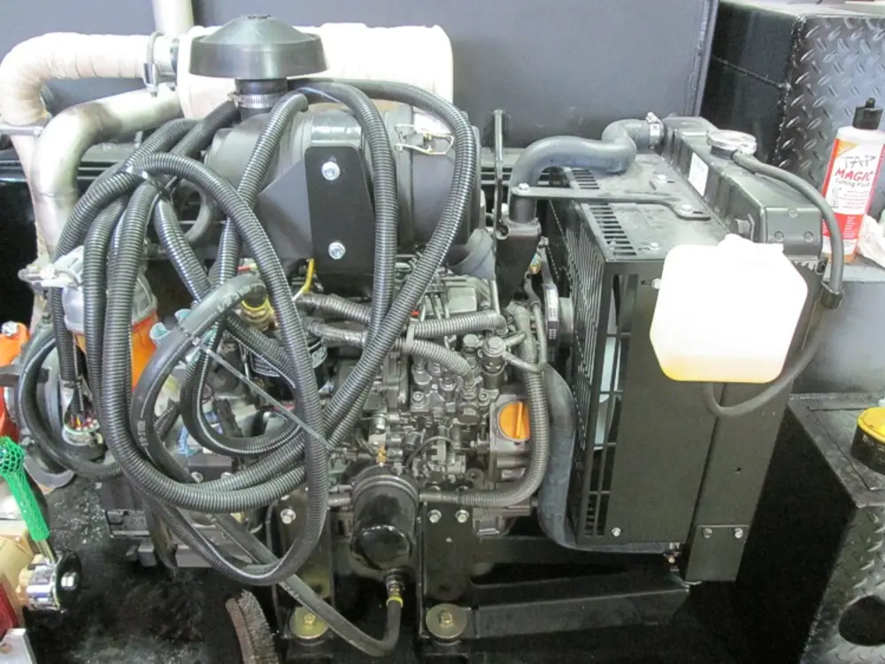 Exterior view of small fire truck showing cab, body compartments, and wheel/tire area.