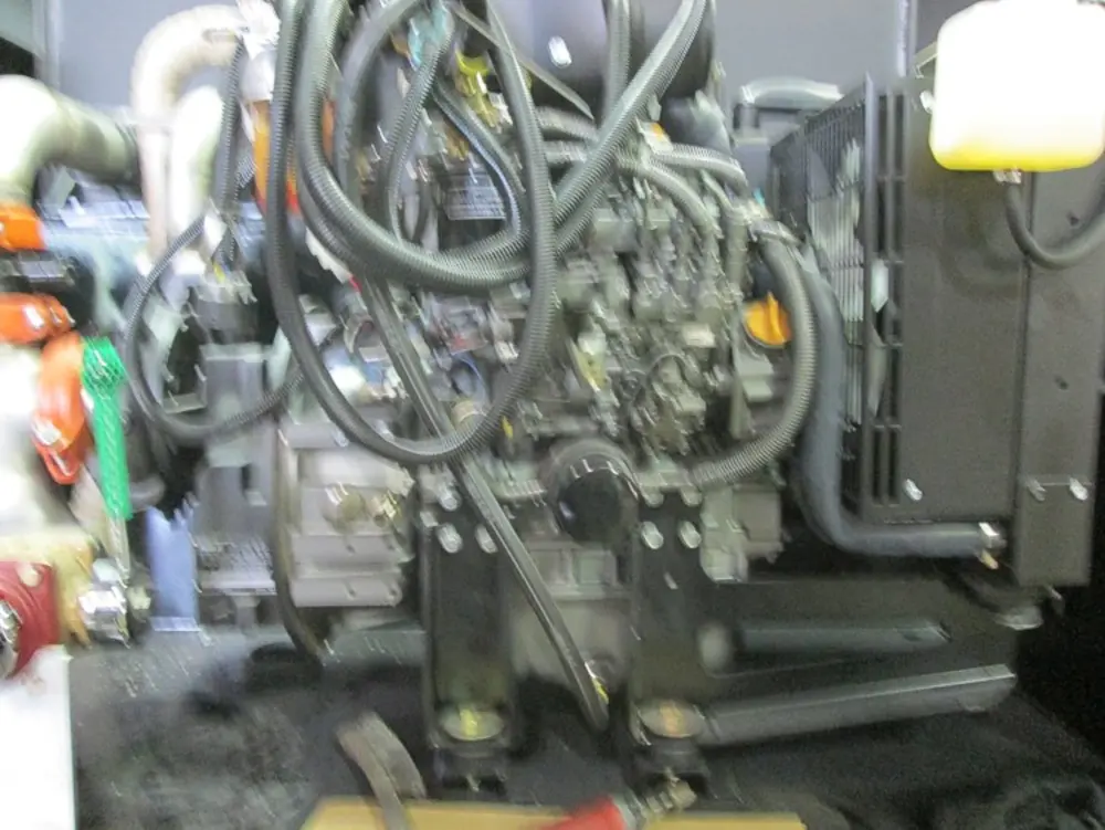 Exterior view of small fire truck showing cab, body compartments, and wheel/tire area.